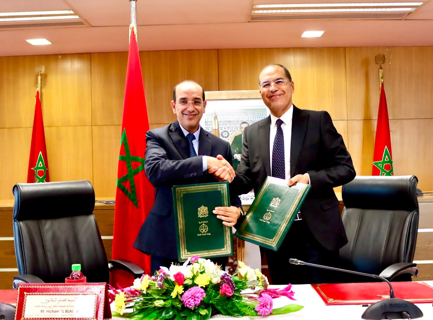 هشام البلاوي الوكيل العام للملك وخاليد سفير المدير العام لصندوق الإيداع والتدبير يتصافحان خلال مراسم توقيع بروتوكول رقمنة إشعارات الموثقين بالرباط